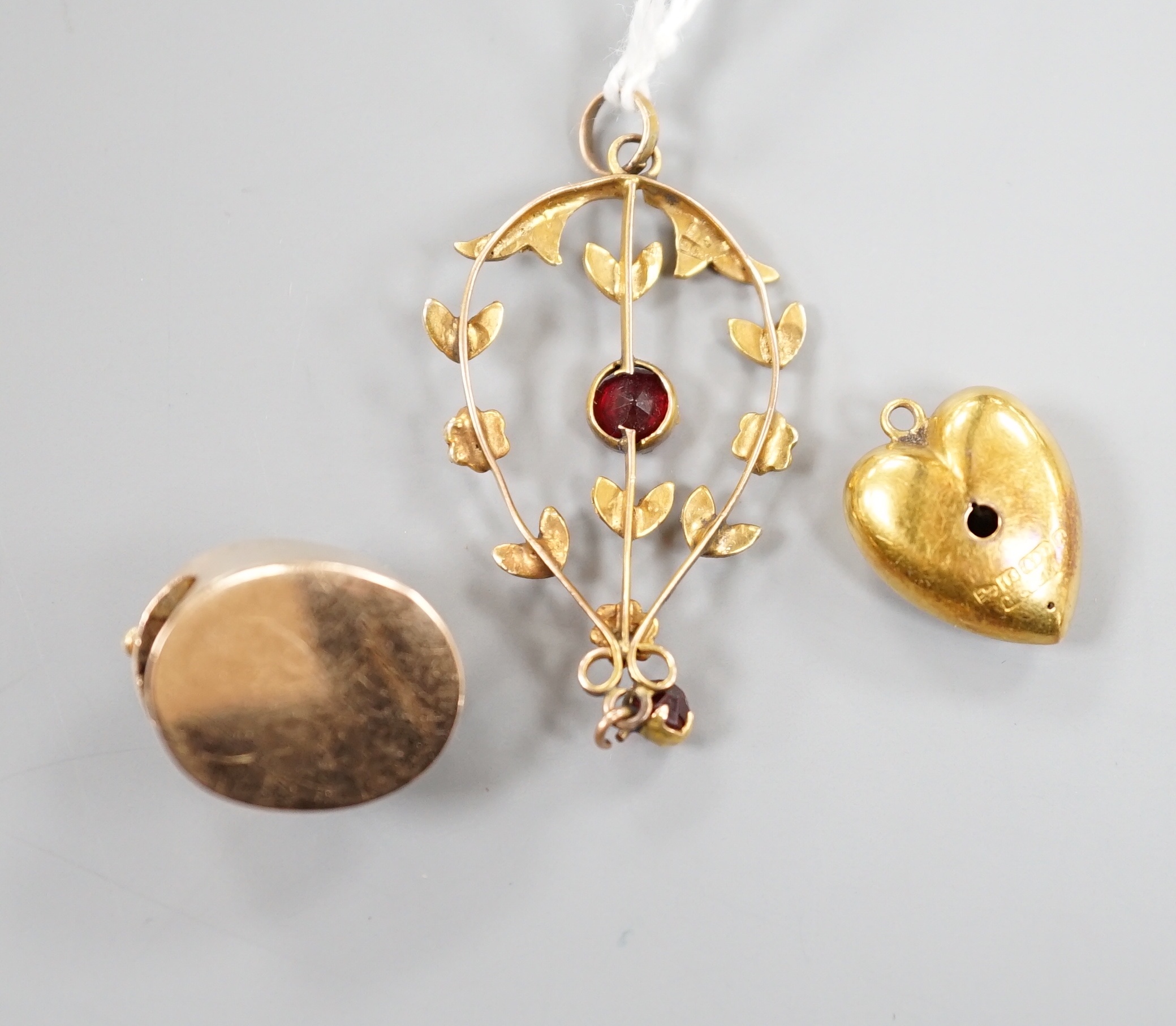 An early 20th century 15ct gold and three stone diamond set heart pendant, 16mm, gross 1.9 grams, an Austro-Hungarian yellow metal and paste set claps and a 9ct, gem and seed pearl set drop pendant, gross 2.6 grams.